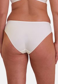 Culotte de bikini blanche en coton avec une texture lisse, présentant une coupe taille basse et des détails de couture minimaux à la taille et aux ouvertures des jambes.