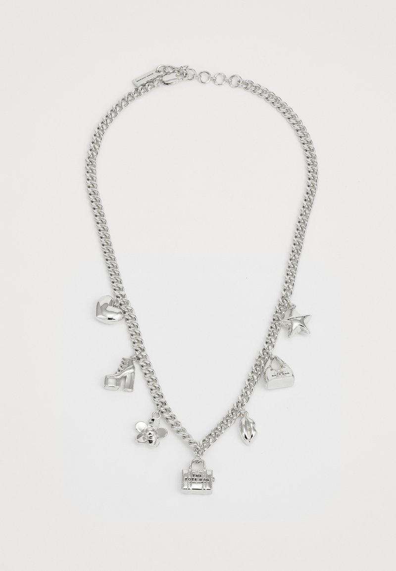 Srebrna verižica z več obeski: srce, visok čevelj, zvezda, torba, cvet in ustnice, vsi z gladkimi in odsevnimi površinami.