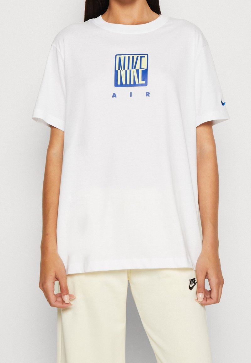 Vit bomull t-shirt med en blå Nike Air-logga på framsidan. Rund halsringning och lös passform med korta ärmar.