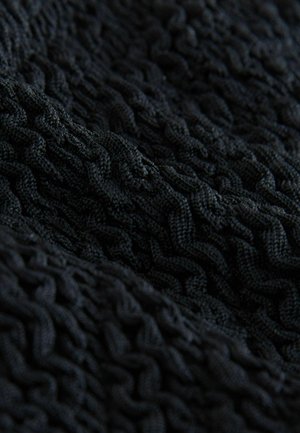 Czarna dziana tkanina prezentująca teksturowany wzór z uniesionymi, falującymi liniami, wyglądająca na miękką i spójną w zbliżeniu.