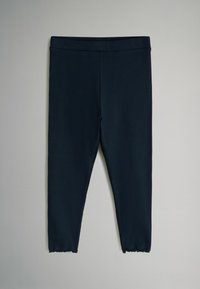 Leggings a coste blu navy con vita elastica liscia e orli sfilacciati alla caviglia, realizzati in un materiale elastico e traspirante.