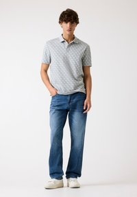Polo shirt gri cu un model, cu mâneci scurte, asortat cu blugi drepți albaștri și teniși albi. Design simplu, cu detalii la guler și tiv.