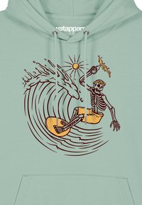 Lichtgroene hoodie met een skelet dat op een golf surft, voorzien van een zon en spuitdetails. Het ontwerp bevat gouden accenten en zwarte outlines.