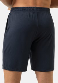 Marineblauwe sportshorts met een elastische tailleband en zijzakken. Gladde textuur met een recht pijpontwerp en gestikte zoom.