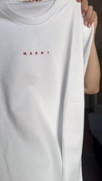 Hvit kortermet t-skjorte med en rød "MARNI" logo over brystet. Stoffet er glatt og lett, med en avslappet passform.