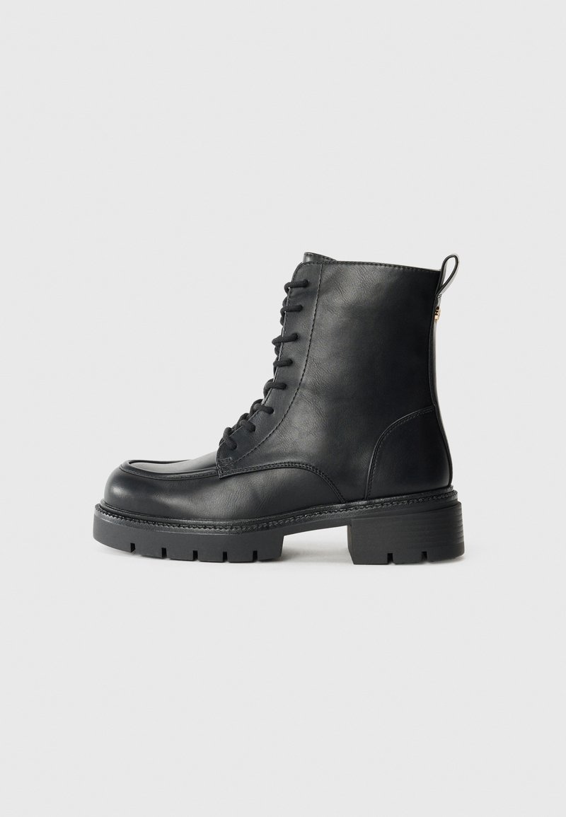 Black leather ankle boots with a round toe, lace-up front, sturdy black rubber sole, and a pull tab at the back for easy wear.