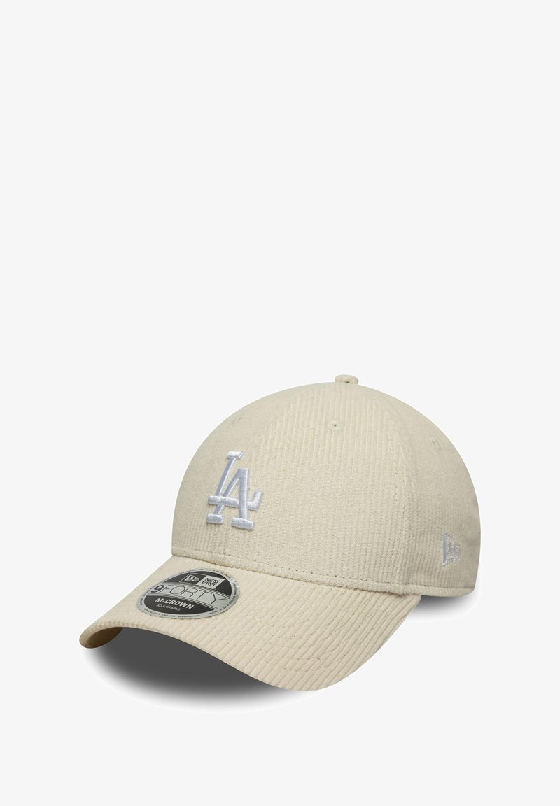 Beige baseball cap with a textured design, featuring an embroidered white "LA" logo on the front and a flat brim.