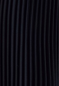 Černá skládáná tkanina s vertikálními pruhy a jemně texturovaným povrchem. Materiál se pod světlem jeví mírně lesklý.