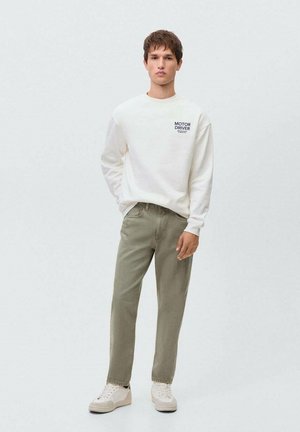 Off-white bomulds sweatshirt med "MOTOR DRIVER" tekst på venstre bryst, parret med lyse olivengrønne bukser og hvide sneakers.