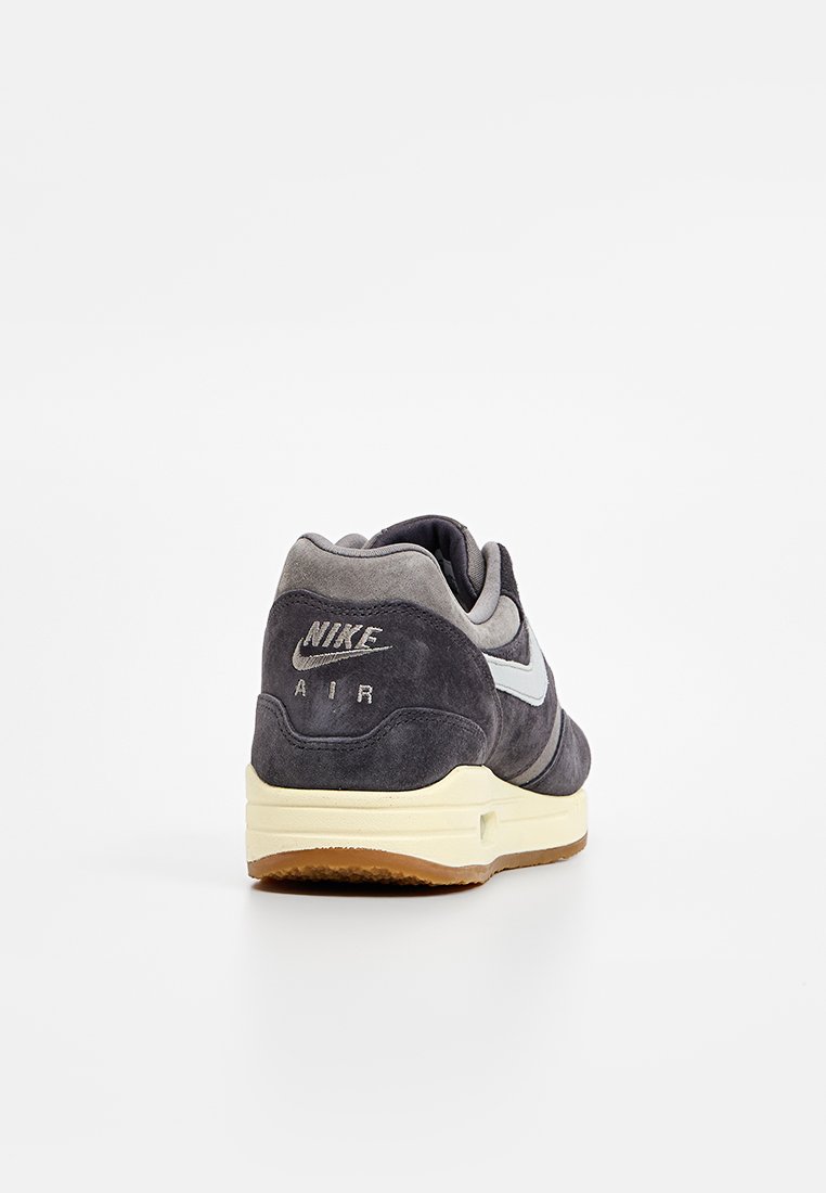 Nike Air sneakers in donkergrijs suède met grijze accenten, voorzien van een rubberen zool en zichtbare Air-demping, logo op de hiel.