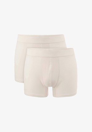 Beige boxershorts met een gladde textuur, met een traditionele uitstraling en gestikte details. Twee paar getoond, met één iets boven de ander.