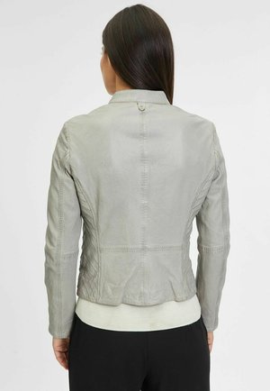 Giubbotto in pelle grigia con un design aderente, cuciture testurizzate e un dettaglio a bottone sul retro. Presenta un orlo bianco a coste.