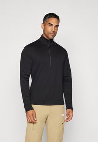 Must have pikkade varrukatega must kapuutsiga tõmblukuga pullover, mis on valmistatud pehmest kangast, pool tõmblukk ja sile tekstuur.
