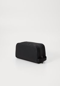 Astuccio per articoli da toeletta nero con tessuto morbido, forma rettangolare, chiusura con zip superiore e maniglia laterale per un facile trasporto. Texture liscia su tutta la superficie.