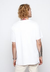 White cotton t-shirt with a relaxed fit, crew neckline, short sleeves, and a straightforward design. Minimalist style with no visible graphics.