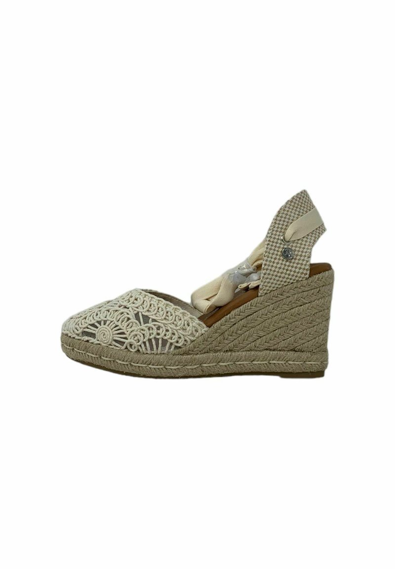 Sandalia de cuña con suela de yute trenzado, parte superior de ganchillo blanca y interior marrón. La correa ajustable presenta un patrón a cuadros y un herraje decorativo.