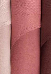 Trois échantillons de tissu pliés en rose clair, rose poussiéreux et mauve, montrant la texture et les coutures cousues.