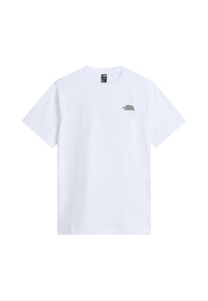 Mand med mørkt hår iført hvid T-shirt med stiliseret "The North Face Never Stop Exploring" grafik på ryggen, kombineret med brune bukser.