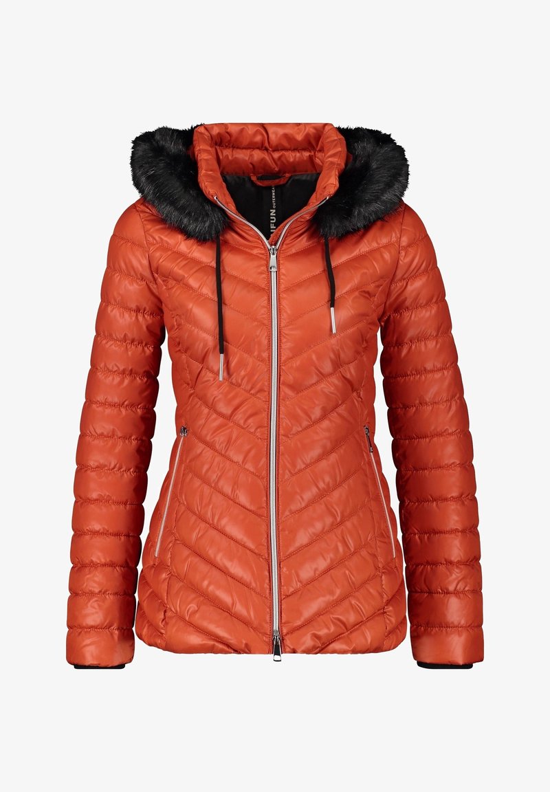 Veste matelassée orange avec capuche en fausse fourrure, fermeture éclair frontale et deux poches latérales. Présente un motif chevron et des poignets élastiques.