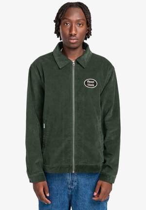 Green corduroy jacket with a collared neckline, front zipper, and an embroidered "Please Think" patch on the chest. Soft texture, relaxed fit.