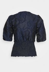 Marineblaue Bluse mit einem strukturierten Blumenmuster, gerüschtem Taillenbund und kurzen Puffärmeln. Hergestellt aus einem leichten, leicht glänzenden Stoff.