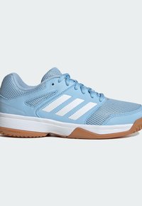 Chaussure de sport bleu clair avec des rayures blanches, des panneaux en mesh, des lacets et une semelle blanche avec une semelle extérieure en caoutchouc marron.