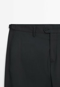 Pantalon noir en tissu lisse, doté d'une fermeture par bouton, de passants pour ceinture et d'une coupe droite classique.