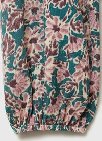 Kangas bermotif bunga dengan nuansa merah muda dan teal. Teksturnya terdiri dari anyaman, dengan elastis yang dihimpun di tepi bagian bawah.