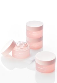 Quattro barattoli di maschera notturna al collagene Abib PDRN in rosa, con una gelatina trasparente all'interno di un barattolo e una spatola di plastica accanto.