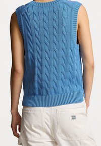 Strickweste ohne Ärmel in Hellblau, mit einem Zopfmuster, geripptem Ausschnitt und Saum, gerader Schnitt und seitlichen Schlitzen.