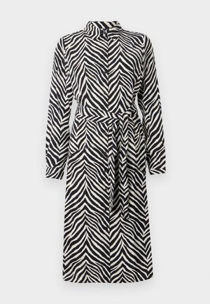 Robe à manches longues avec un motif rayé noir et blanc de zèbre et une ceinture en tissu assortie à la taille.