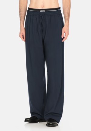 Pantaloni blu navy, larghi, con cintura elastica e cordoncino. Realizzati in tessuto leggero, presentano una trama morbida.