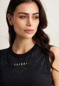 Top nero senza maniche con scollo rotondo, caratterizzato da un sottile motivo testurizzato e logo dorato "FREDDY" sul davanti. Tessuto morbido.