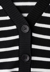 Sort og hvid stribet cardigan med V-udskæring, der har en ribbet tekstur og to sorte knapper foran.