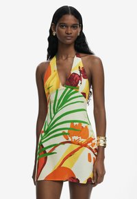 Floral-patterned mini dress with a plunging neckline, vibrant colors like yellow, red, and green, and a halter neck design. Smooth fabric.