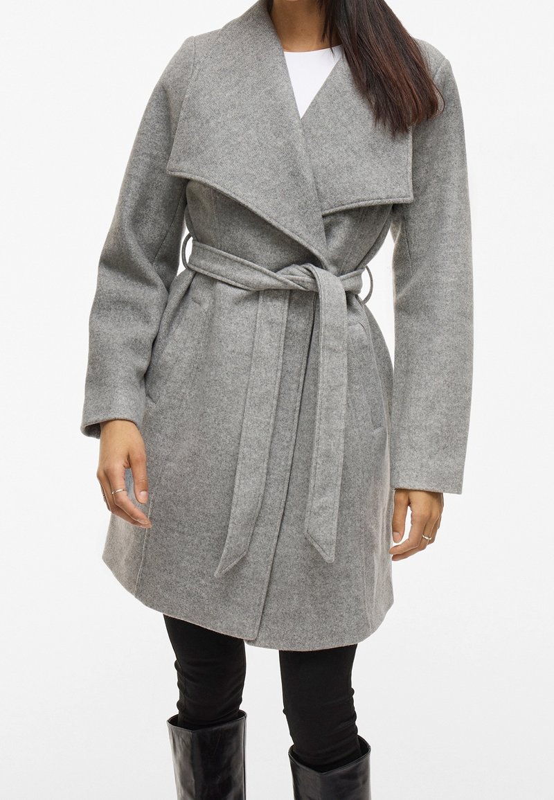 Szary wełniany płaszcz z szerokim kołnierzem, paskiem w talii, kieszeniami po bokach i długimi rękawami, o miękkiej teksturze i długości do kostek.
