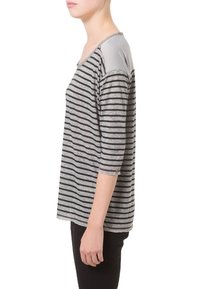 Top a rayas con franjas horizontales en gris y negro, mangas tres cuartos, tela ligera y un cuello redondeado con acentos en los hombros.