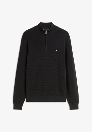 Fekete pulóver texturált, bordázott mintával. Magas nyakrésszel és rövid cipzárral rendelkezik. Kis logó a mellrészen.