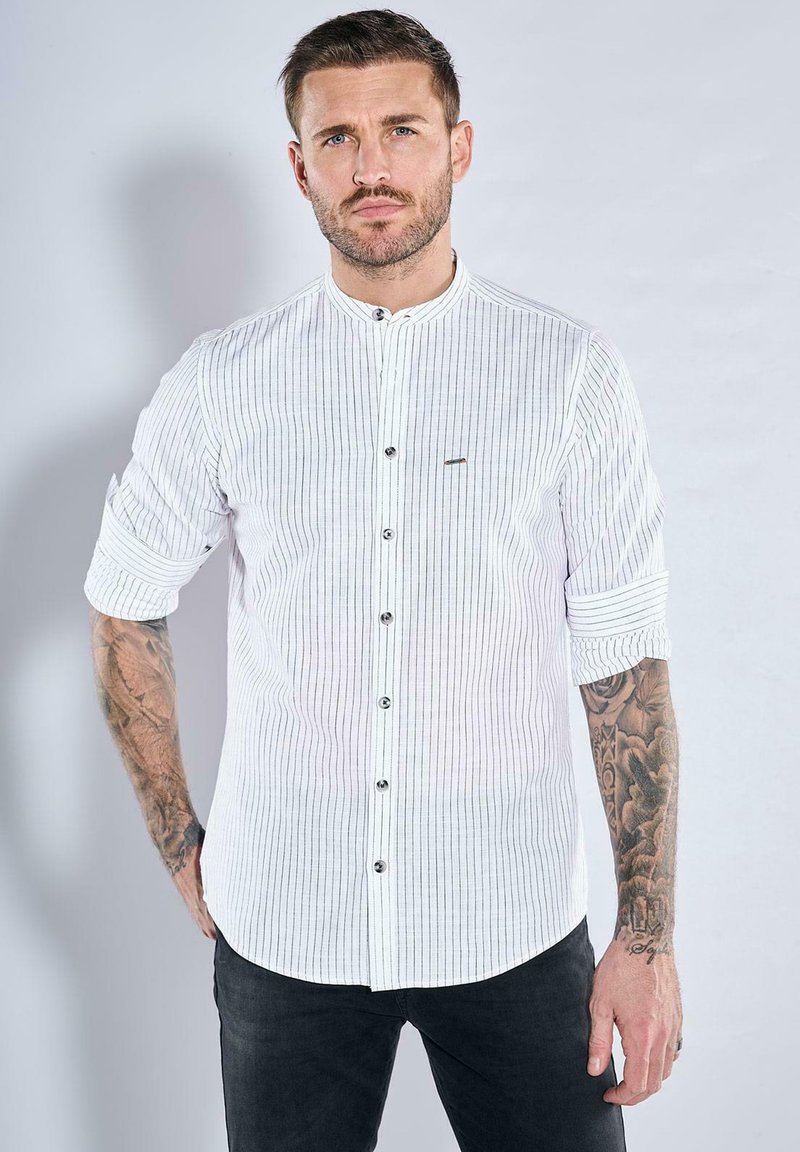 Weißes, kurzärmeliges Hemd mit vertikalen schwarzen Streifen, umgeschlagenen Ärmeln, Mandarin-Kragen und schwarzen Knöpfen, mit subtilen Logodetails.
