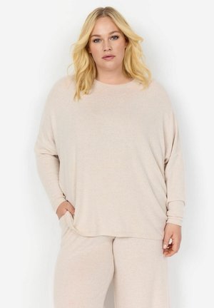 Top de manga larga beige con un corte relajado y escote redondeado. Textura suave con un sutil patrón jaspeado. Bolsillos ubicados a los lados.