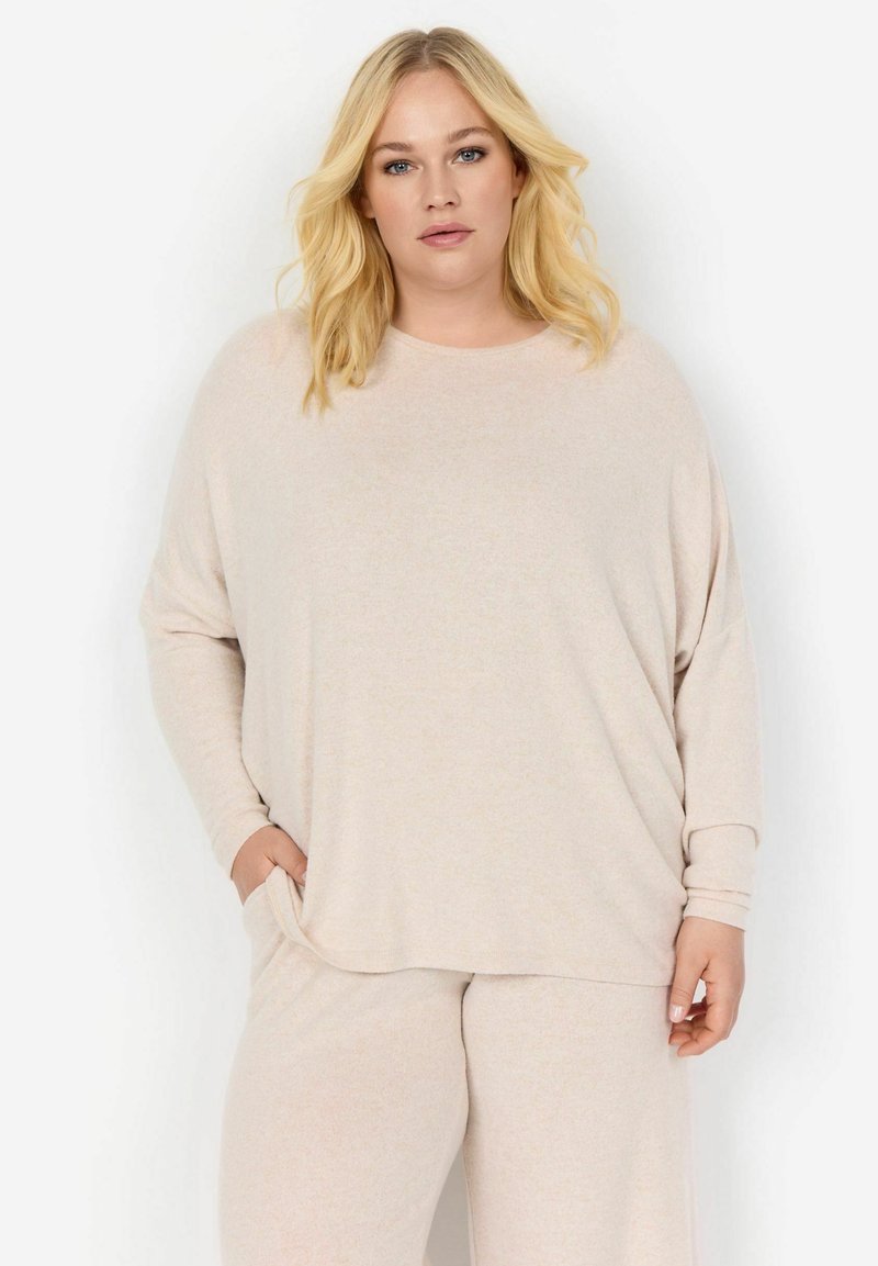 Maglia beige a maniche lunghe con una vestibilità rilassata e scollo arrotondato. Texture morbida con un sottile motivo melangiato. Tasche posizionate sui lati.