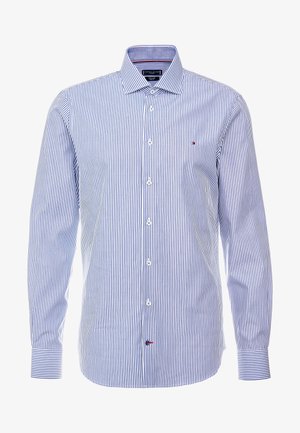 Chemise habillée homme à manches longues avec rayures verticales bleues et blanches, devant boutonné et petit logo sur la poitrine et en bas devant.