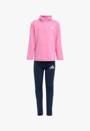 Rosa langärmliges zip-freies Oberteil mit hohem Kragen, kombiniert mit marineblauen Leggings mit rosa Akzenten und einem Logo. Hergestellt aus leichtem, elastischem Material.