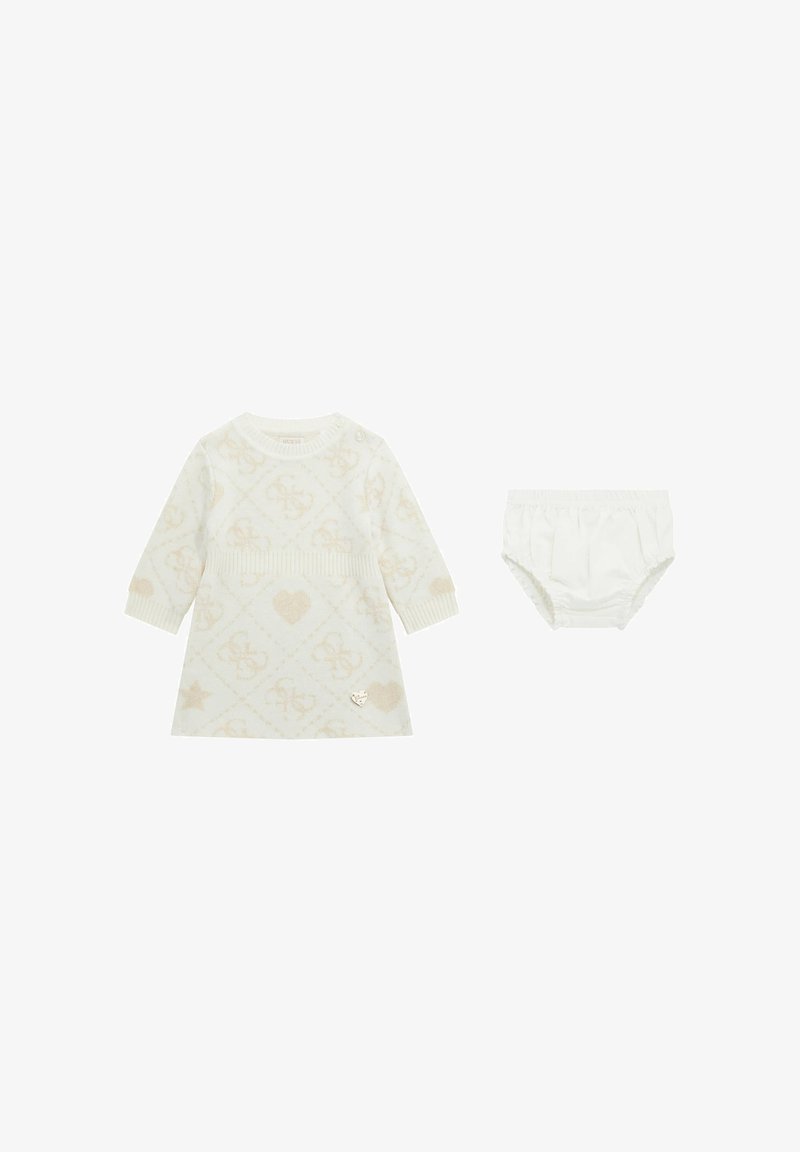 Witte gebreide jurk met lange mouwen, met een subtiel patroon van harten en sterren, gecombineerd met bijpassende witte bloomer shorts.