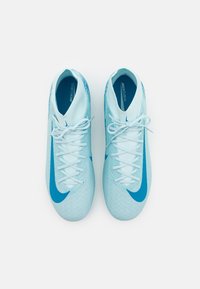 Jasnoniebieskie buty piłkarskie z teksturowaną cholewką, z wyraźnym ciemnoniebieskim logo Nike i standardowymi białymi sznurowadłami.