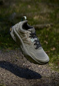 Basket de sport grise avec tige en mesh, accents texturés, lacets noirs et semelle en caoutchouc. Présente un rembourrage "Fresh Foam" et une languette de traction.