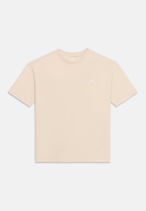 Camiseta beige de manga corta con cuello redondo y un pequeño logo de la marca en blanco en el pecho izquierdo, mostrada plana sobre un fondo claro.