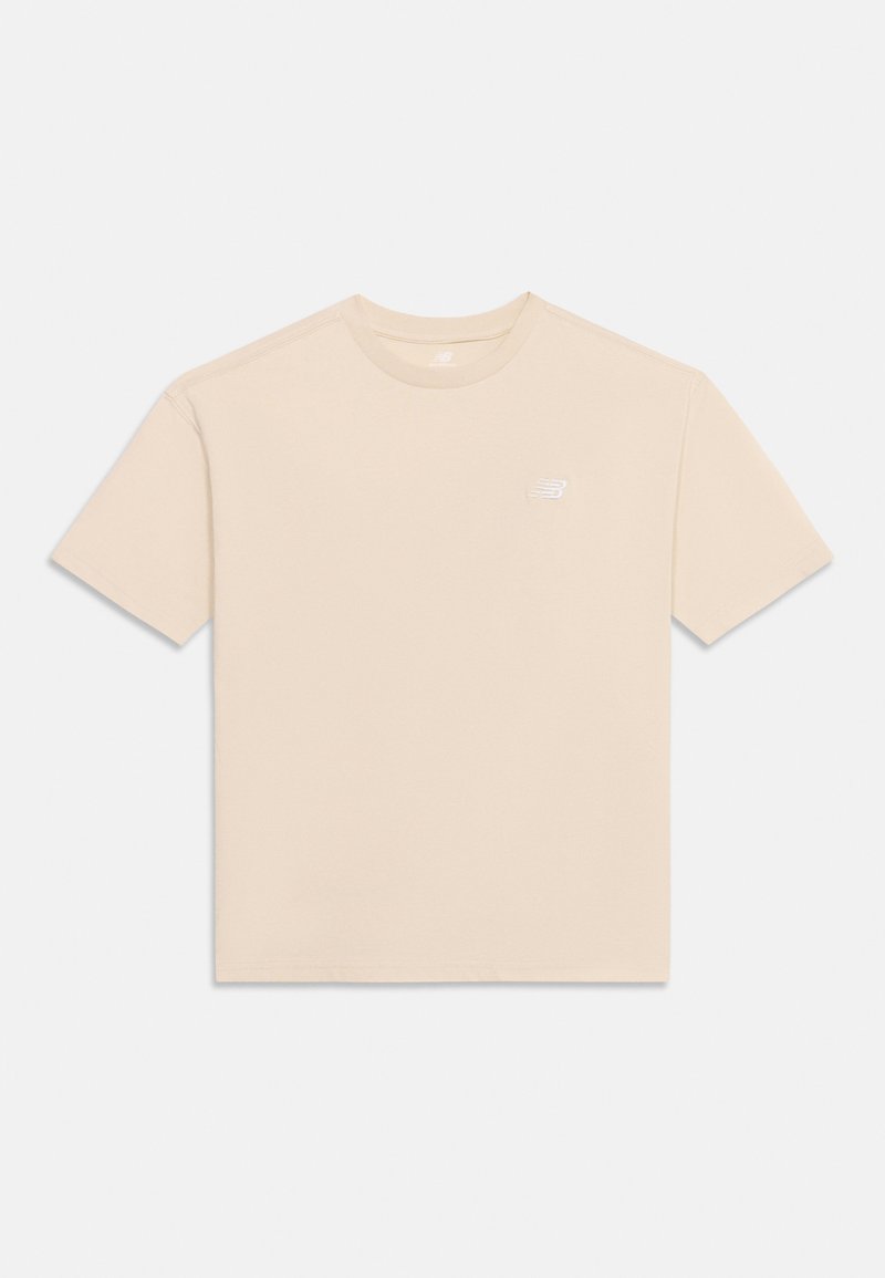 Μπεζ T-shirt με κοντά μανίκια και λαιμόκοψη, με μικρό λευκό λογότυπο της μάρκας στο αριστερό στήθος, εμφανίζεται απλωμένο σε ανοιχτό φόντο.