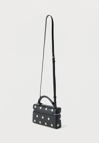 Zwarte rechthoekige crossbodytas met zilverkleurige ronde studs, bovenhandvat, verstelbare schouderriem en een ritssluiting aan de bovenkant.