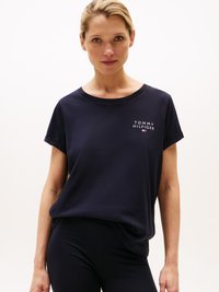 Mörkblå bomullströja med rullade korta ärmar, med en vit logotyp "TOMMY HILFIGER" och en liten färgad flaggdetalj.
